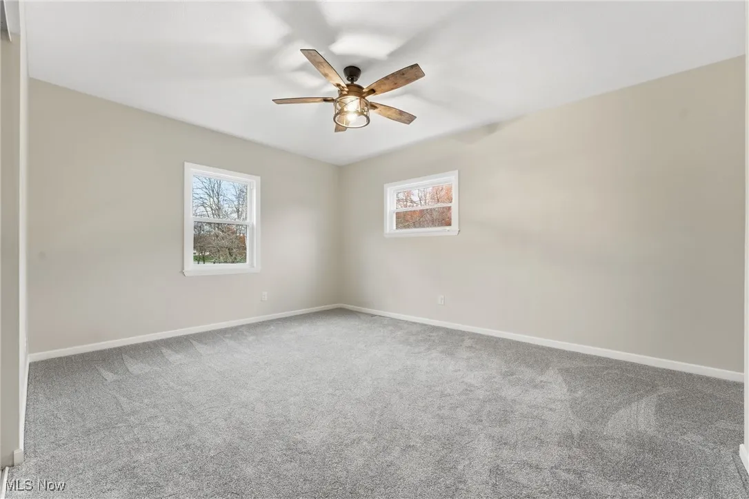 Spare room featuring carpet and a ceiling fan