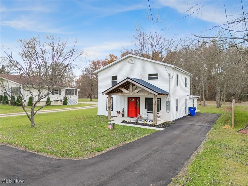 View of front of property with a front lawn, a porch, and driveway