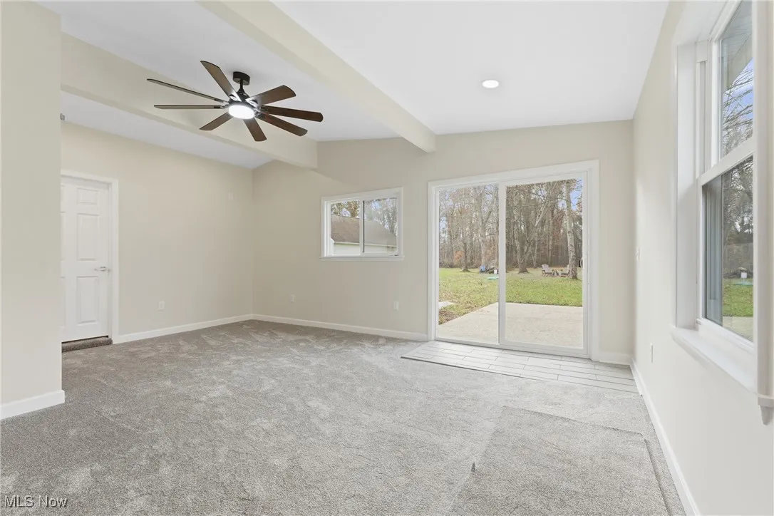 Spare room featuring light colored carpet and ceiling fan