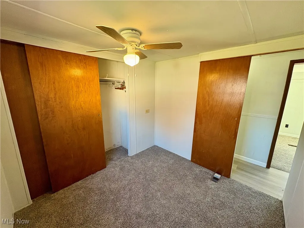 Unfurnished bedroom featuring carpet floors, a closet, and a ceiling fan