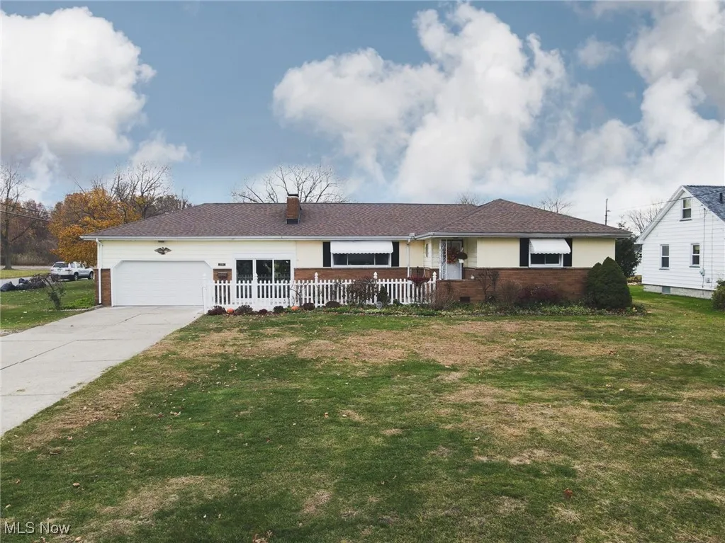 Ranch-style house featuring a front yard, brick siding, and concrete driveway
