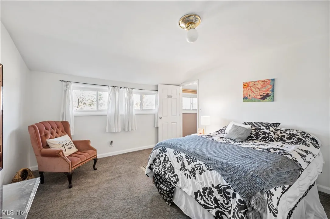 Bedroom with carpet flooring and vaulted ceiling