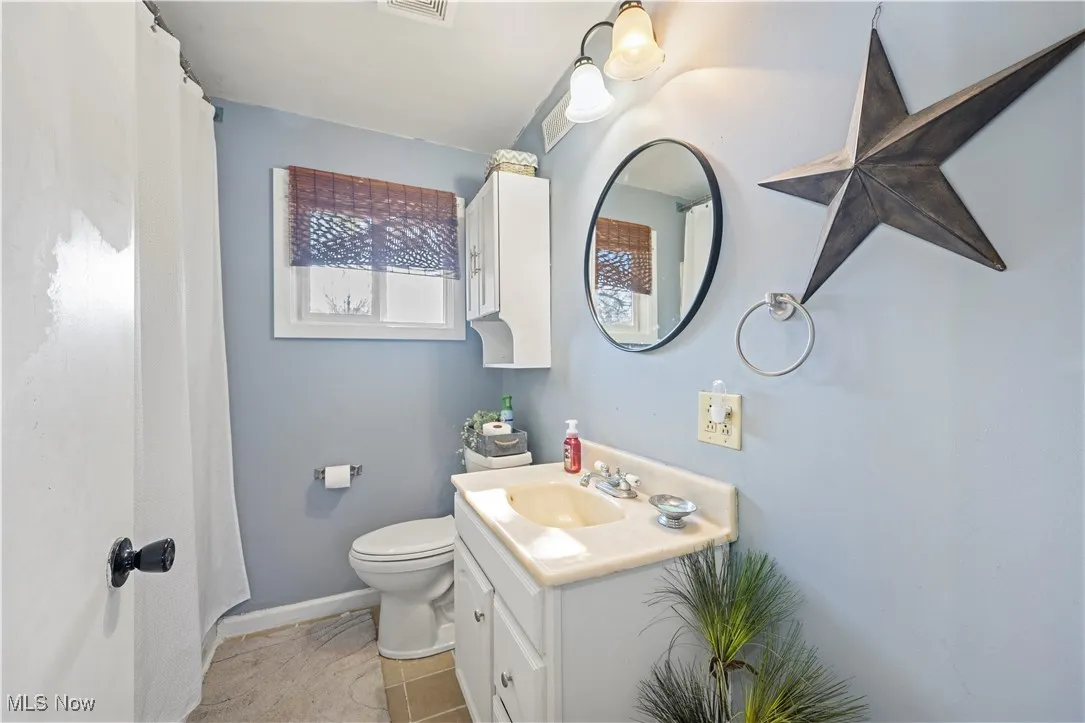 Bathroom with vanity, curtained shower, and light tile patterned floors