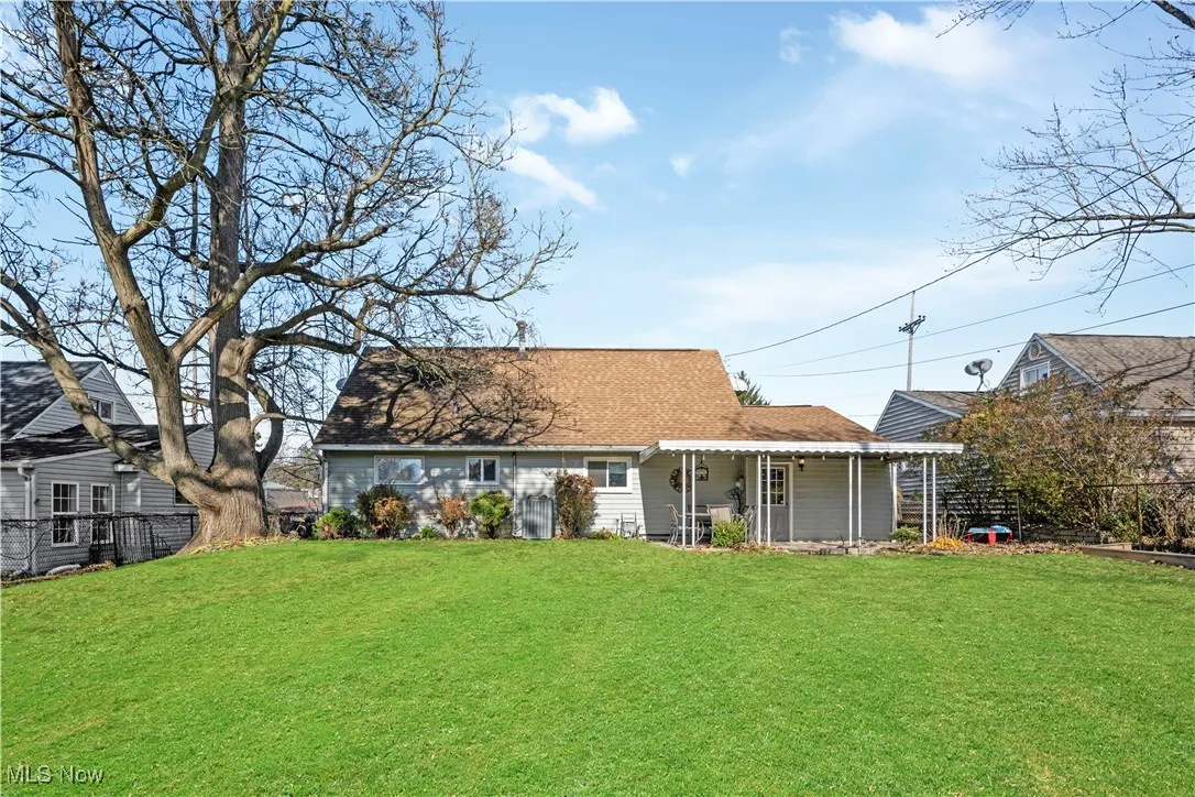Back of house featuring a shingled roof and covered porch