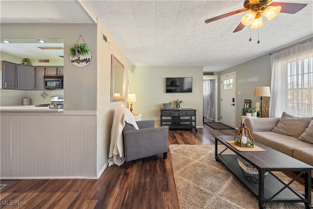 Living area featuring ceiling fan and dark wood finished floors