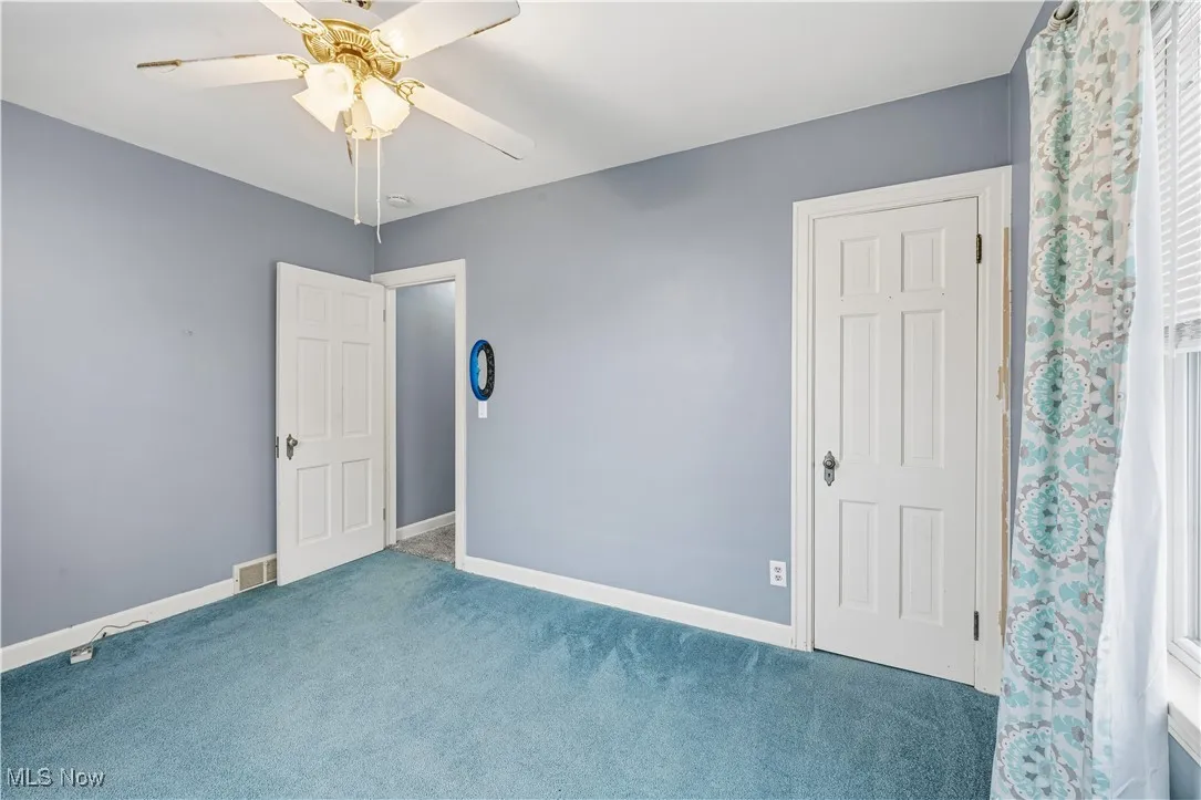 Unfurnished bedroom with carpet floors and a ceiling fan