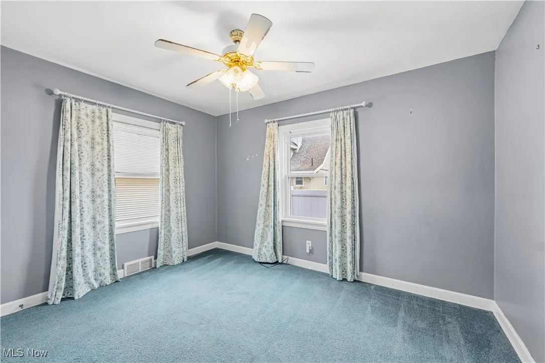 Spare room with carpet and a ceiling fan
