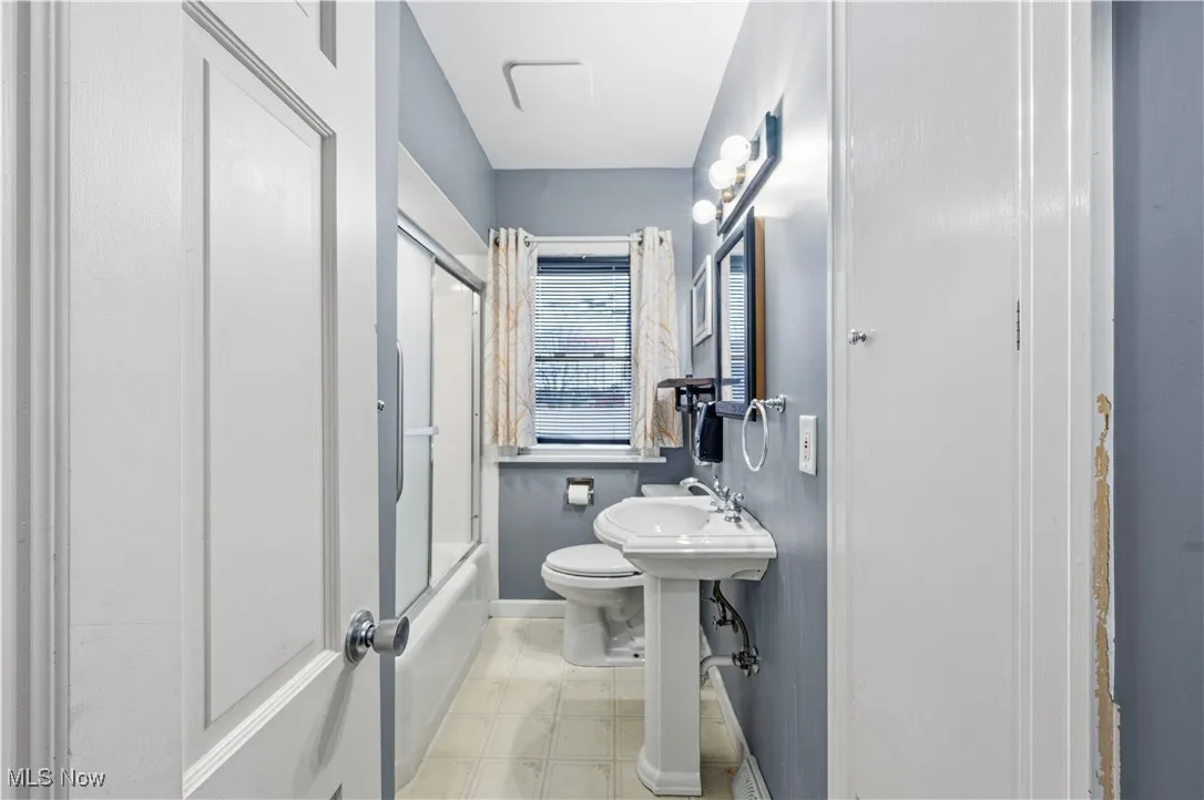 Bathroom featuring toilet and enclosed tub / shower combo