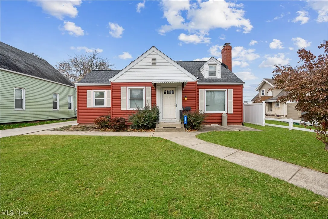 View of front facade with a chimney and a shingled roof