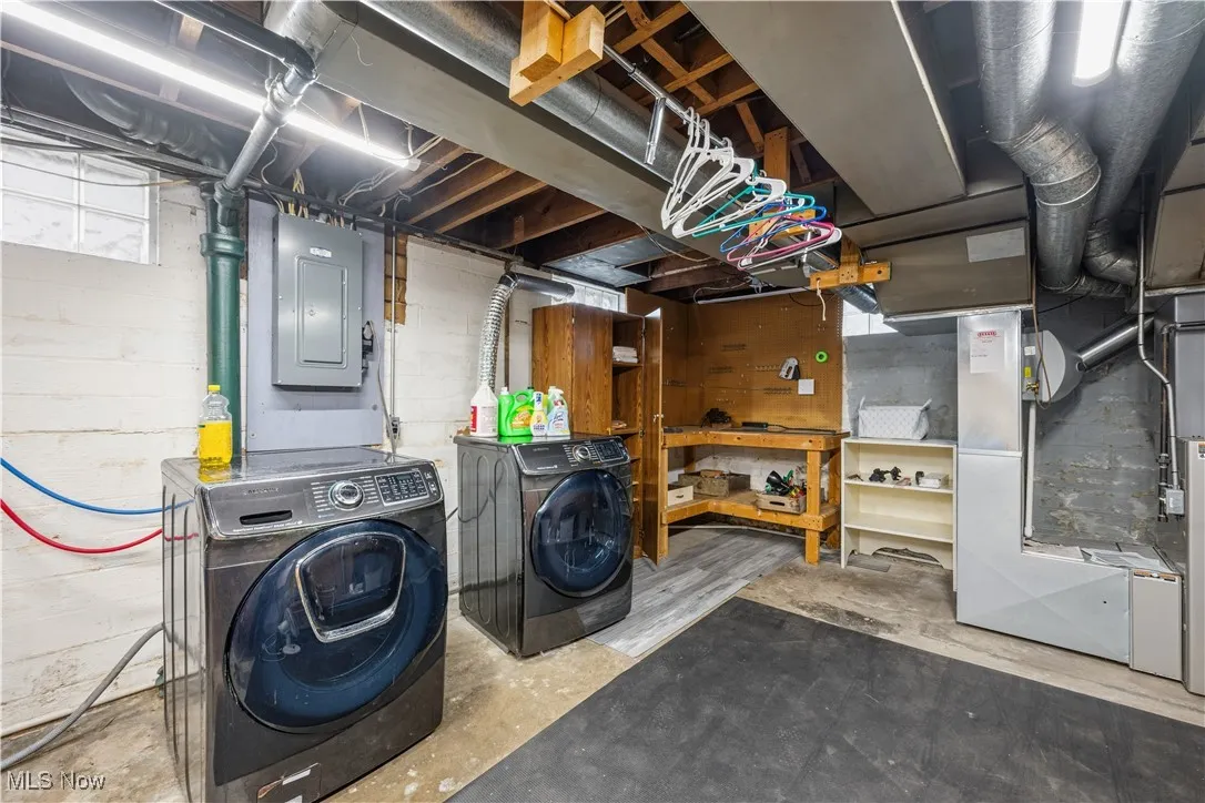 Unfinished basement with washer and dryer and electric panel