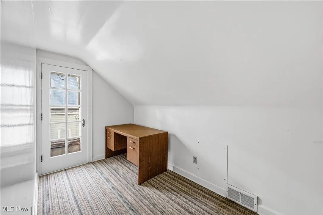 Bonus room featuring vaulted ceiling and carpet