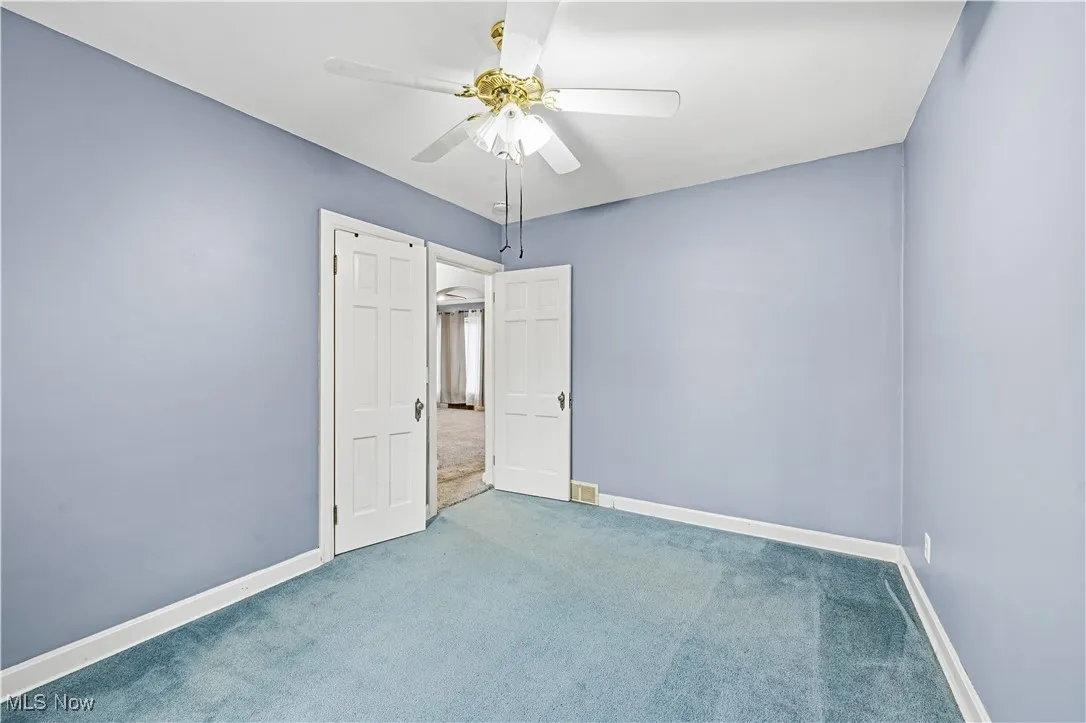 Unfurnished bedroom with carpet floors and ceiling fan