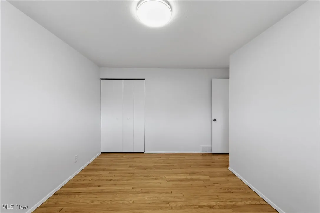 Unfurnished bedroom with light wood-style flooring and a closet