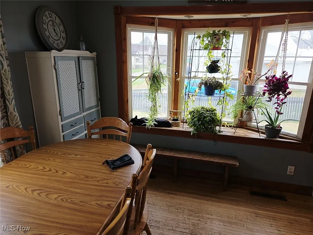Dining room with wood-type flooring and baseboards