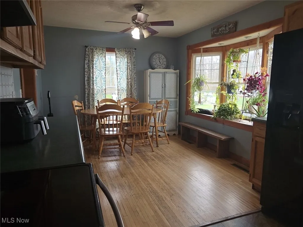 Dining area with a ceiling fan and light wood finished floors