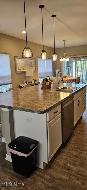 Kitchen featuring an island with sink, vinyl wood-style floors, white cabinetry, and healthy amount of natural light