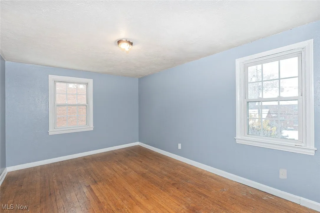 Empty room featuring dark wood-style flooring and a textured ceiling
