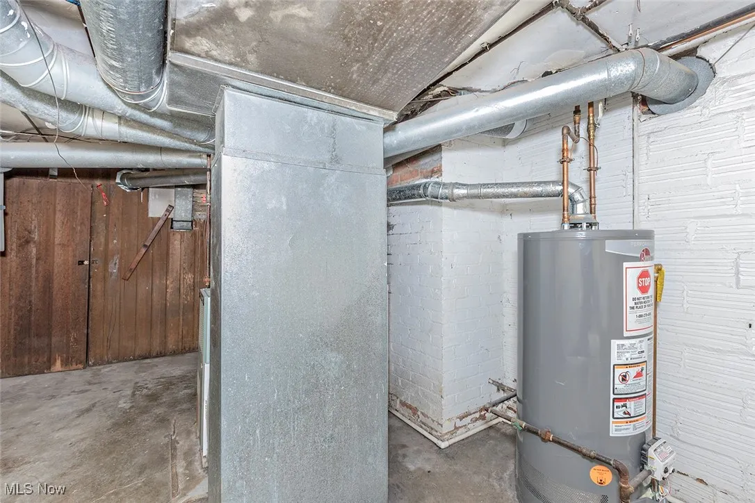 Utility room featuring water heater and heating unit