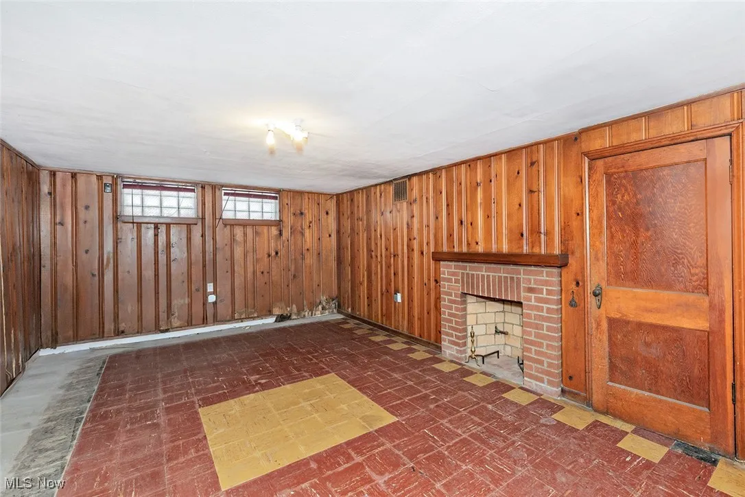 Basement featuring a fireplace and wood walls
