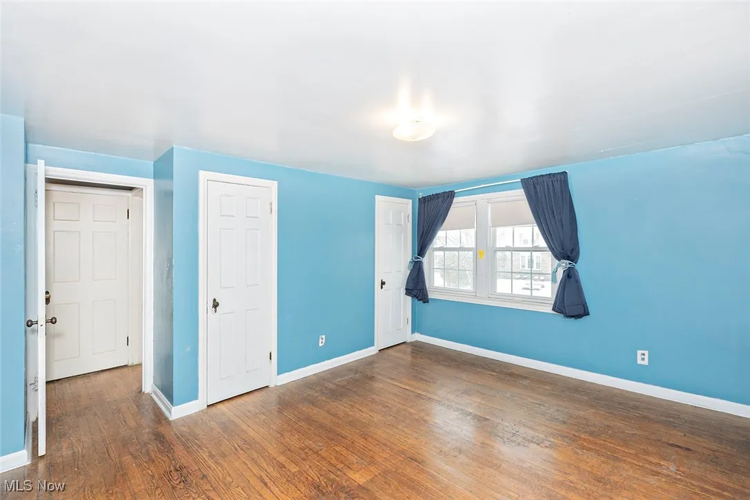 Unfurnished bedroom with dark wood finished floors and a closet