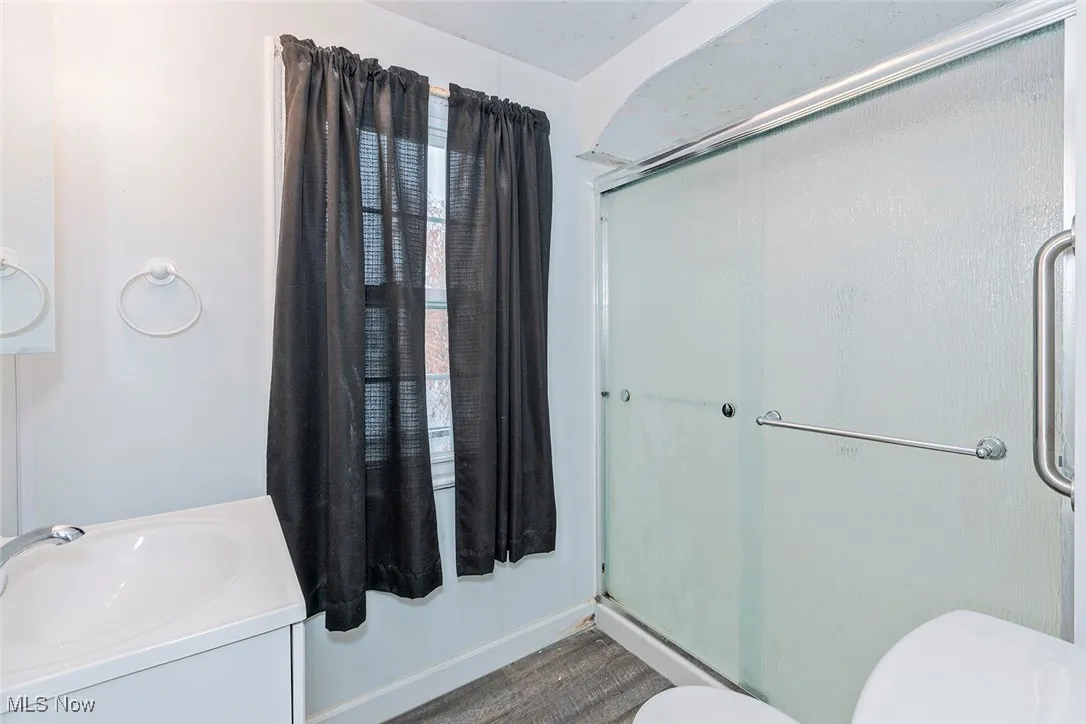 Bathroom featuring vanity and a shower with door