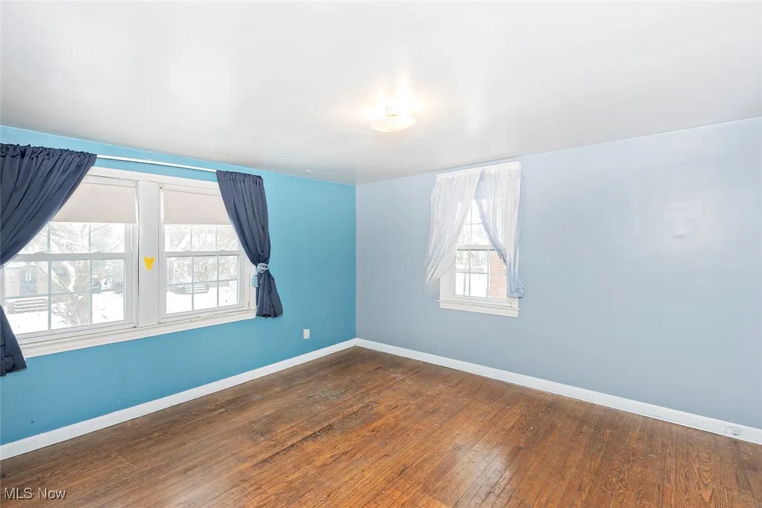 Empty room with wood-type flooring and baseboards