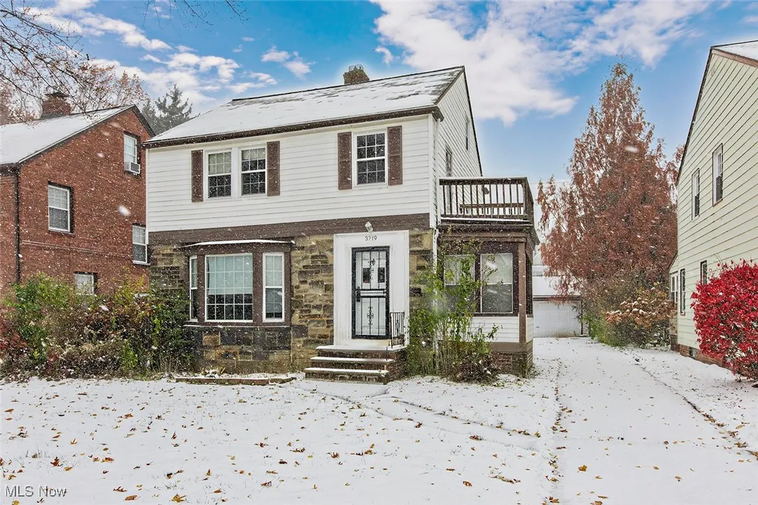 Traditional home with stone siding and a balcony