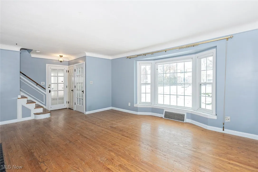 Unfurnished living room with light wood-type flooring and stairway