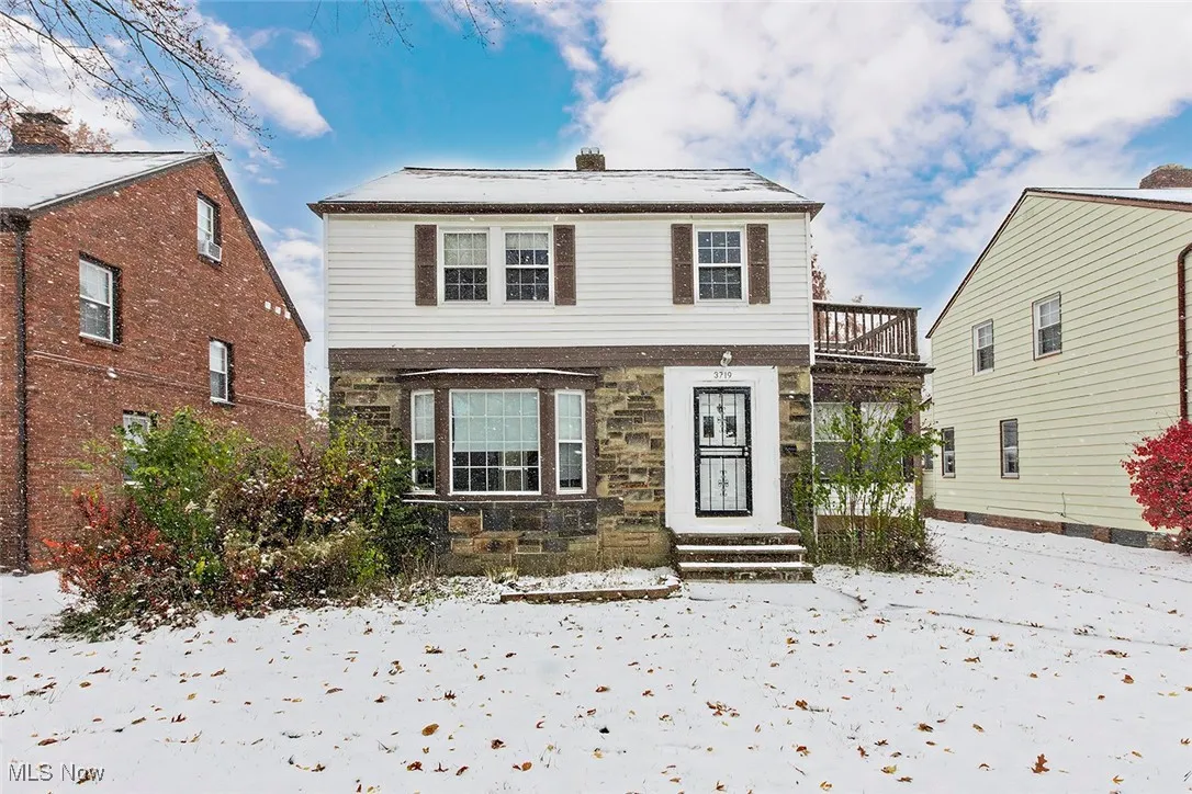 Traditional home with stone siding and a chimney