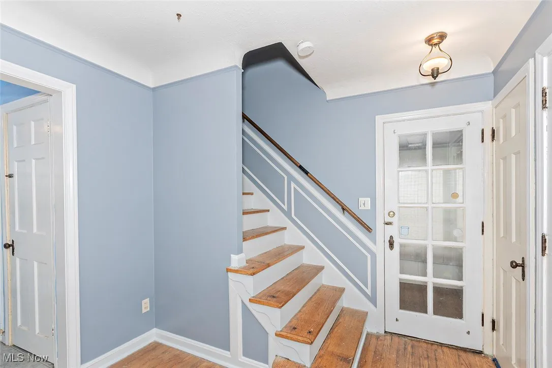Stairway with wood finished floors and baseboards