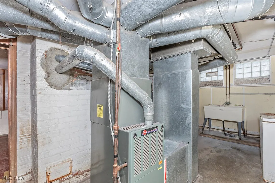 Utility room featuring heating unit and a sink
