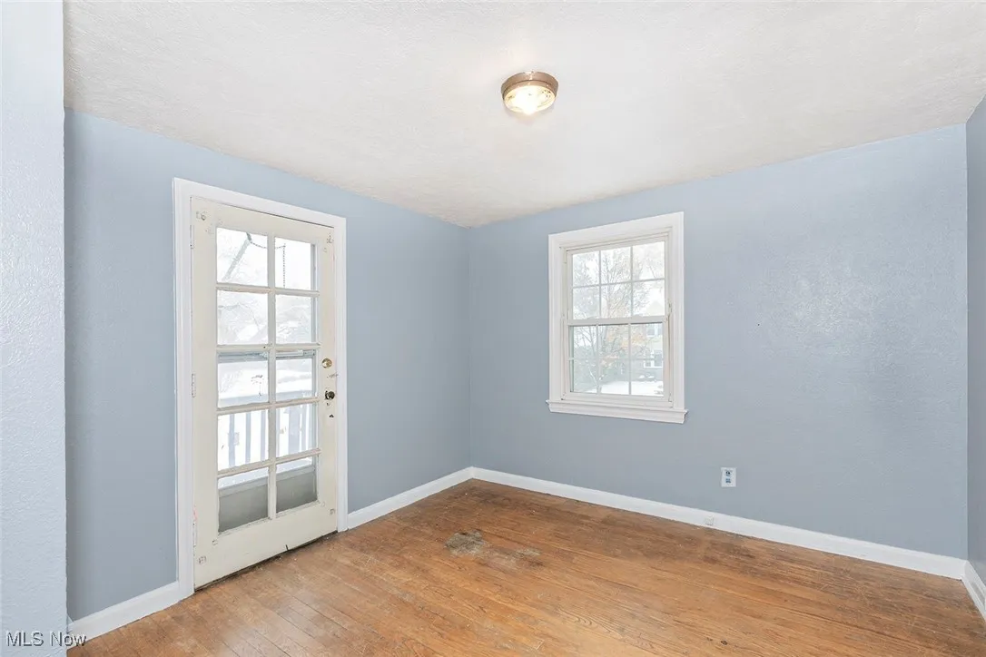 Empty room with baseboards and hardwood / wood-style flooring