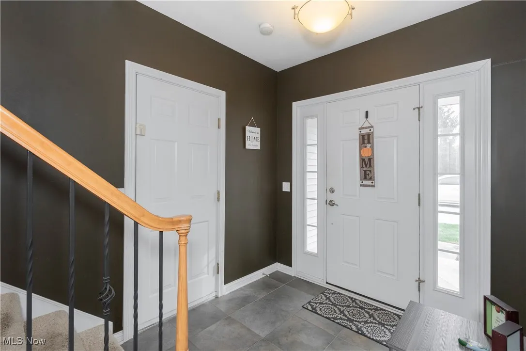 Entrance foyer with stairway and baseboards