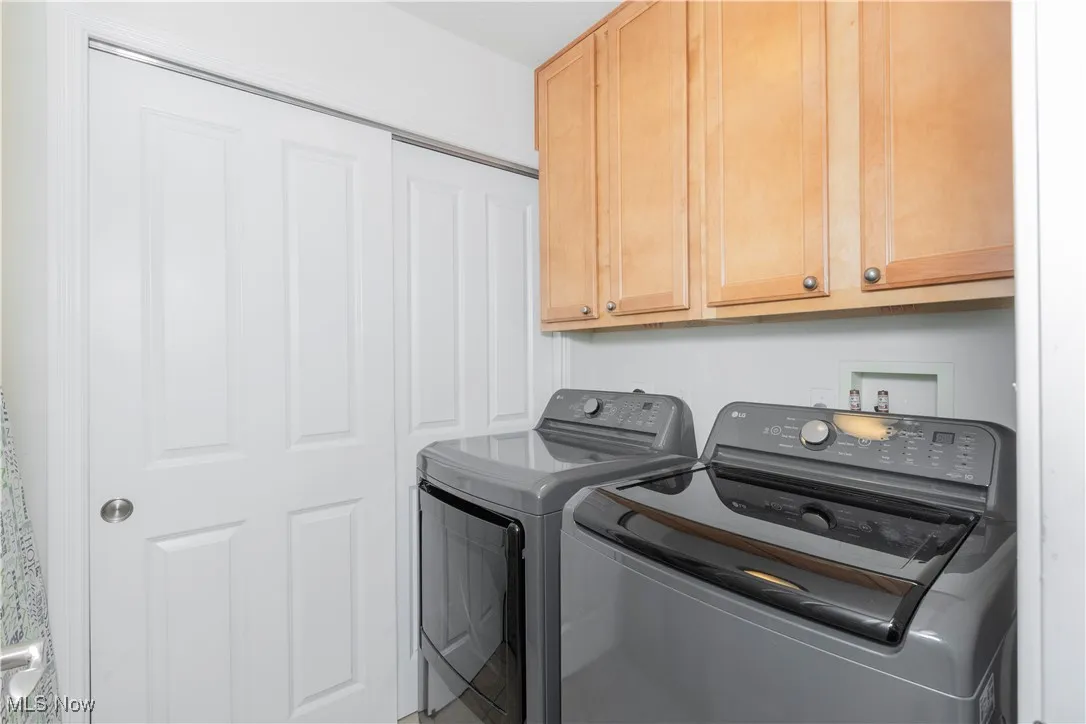 Washroom featuring washing machine and dryer and cabinet space