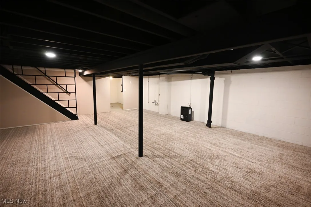 Finished below grade area featuring stairs and carpet flooring