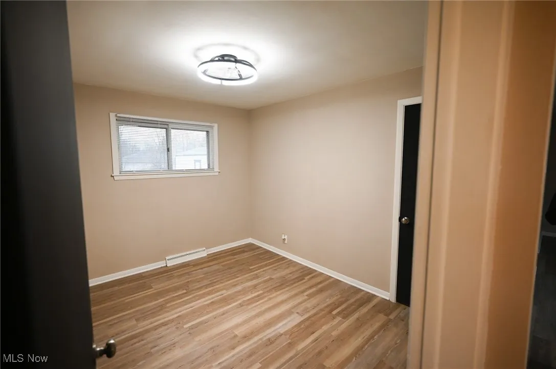 Empty room featuring light wood finished floors and baseboards
