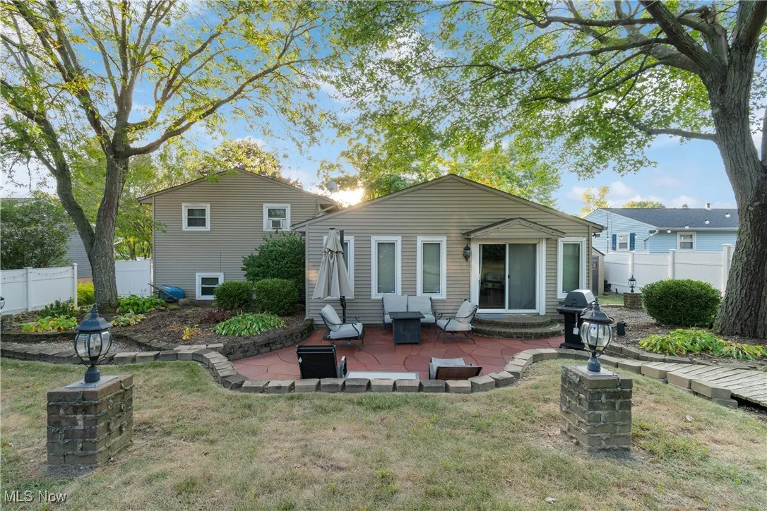 Back of house with a fenced backyard and a patio