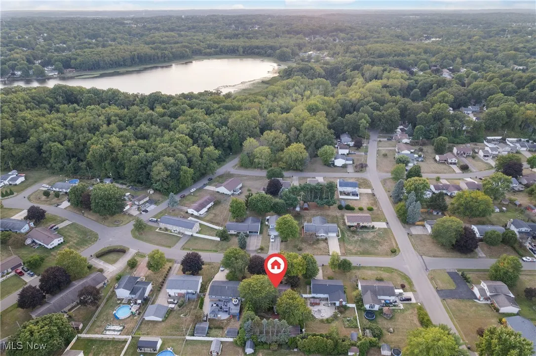 Aerial view of property's location with a nearby body of water and nearby suburban area