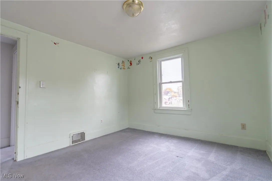 Carpeted empty room featuring baseboards