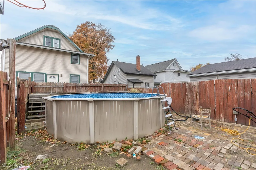 Rear view of property with a fenced backyard and a patio