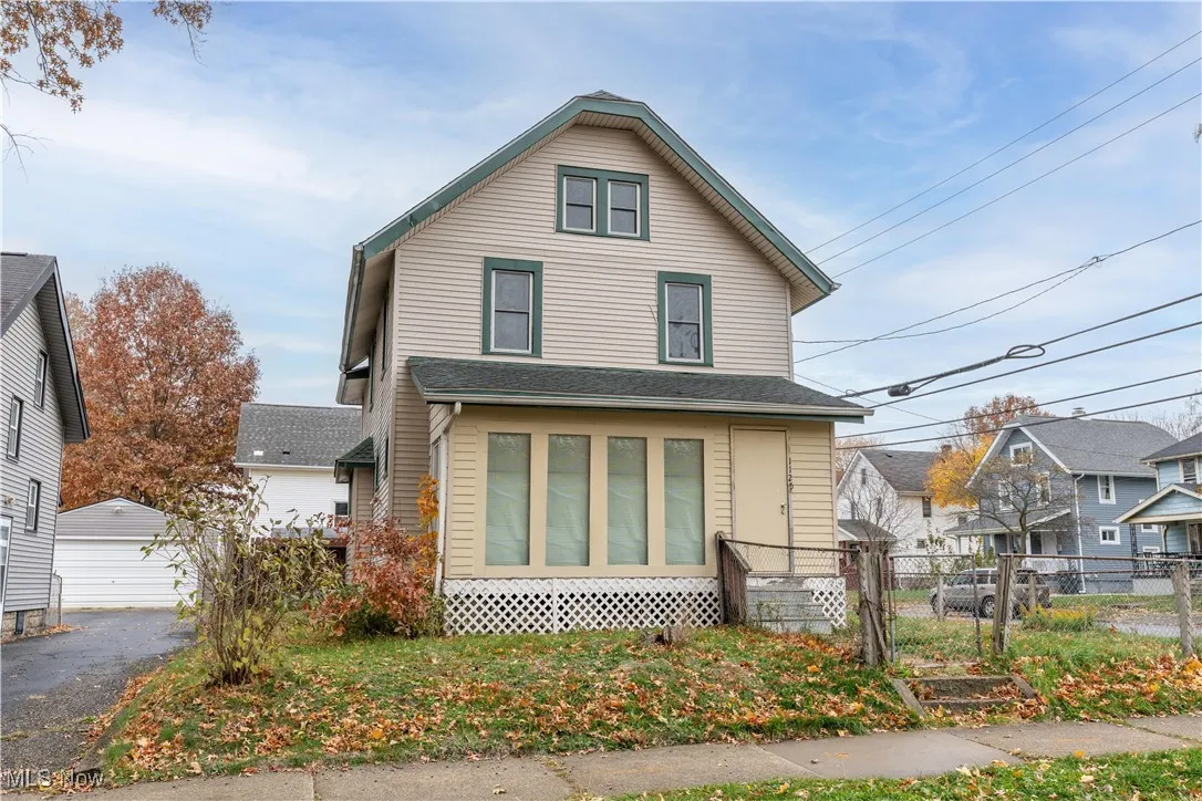 American foursquare style home featuring a detached garage and an outbuilding