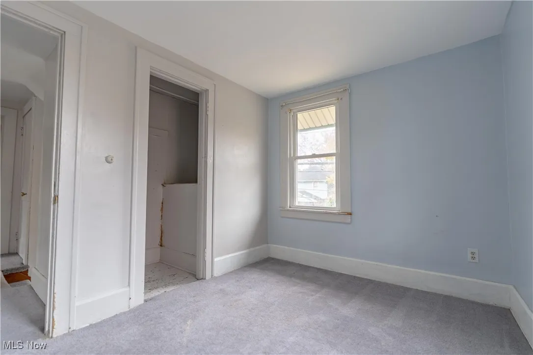 Unfurnished bedroom featuring carpet floors and baseboards