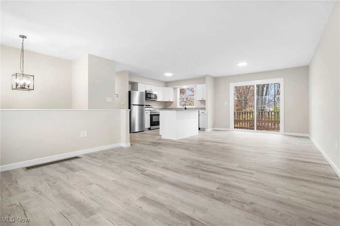 Unfurnished living room featuring light wood finished floors, recessed lighting, and a chandelier