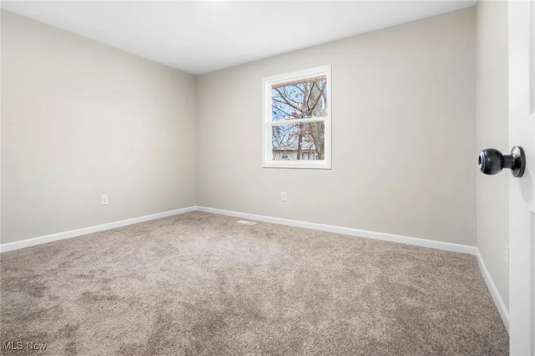 Empty room with carpet and baseboards