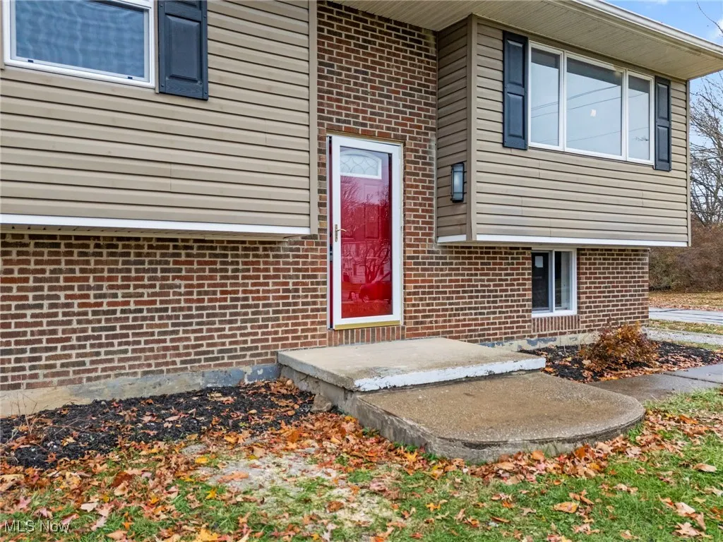 View of exterior entry featuring brick siding