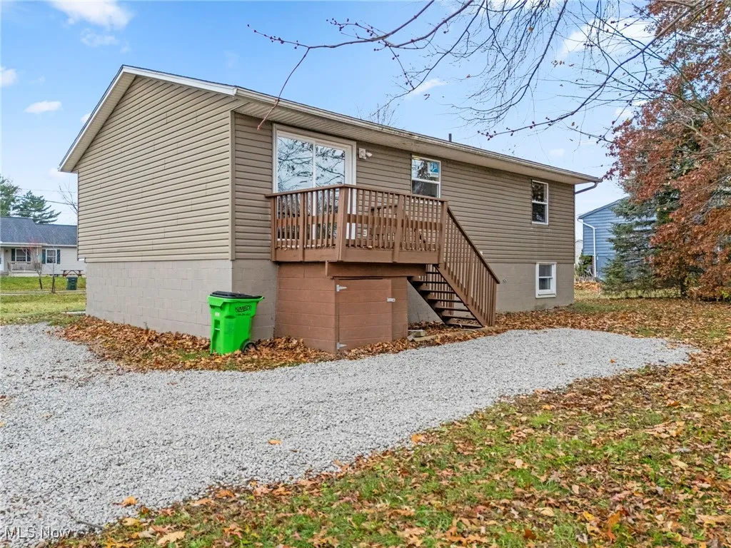 Back of property with a wooden deck and stairway