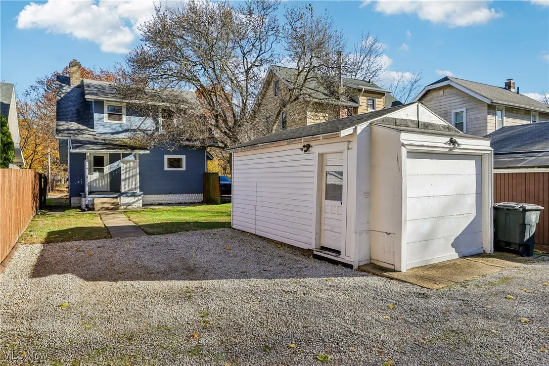 View of 1 car detached garage and driveway parking behind the home