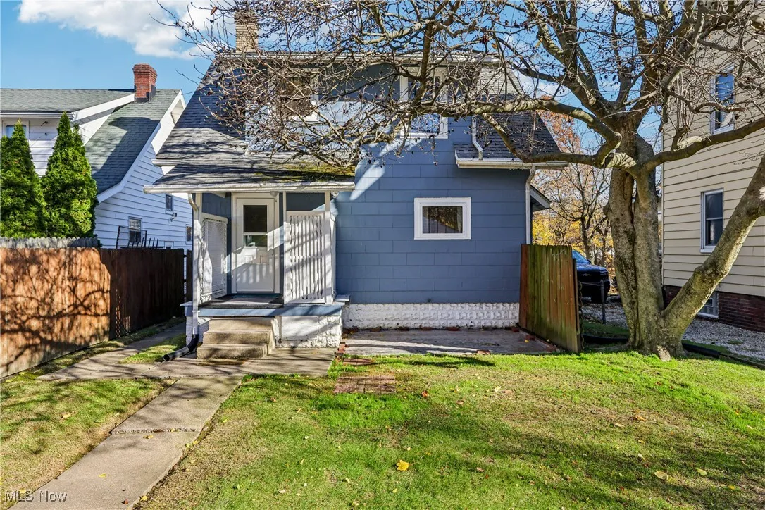 Rear view of the property with small back porch, patio, wood fencing and back yard