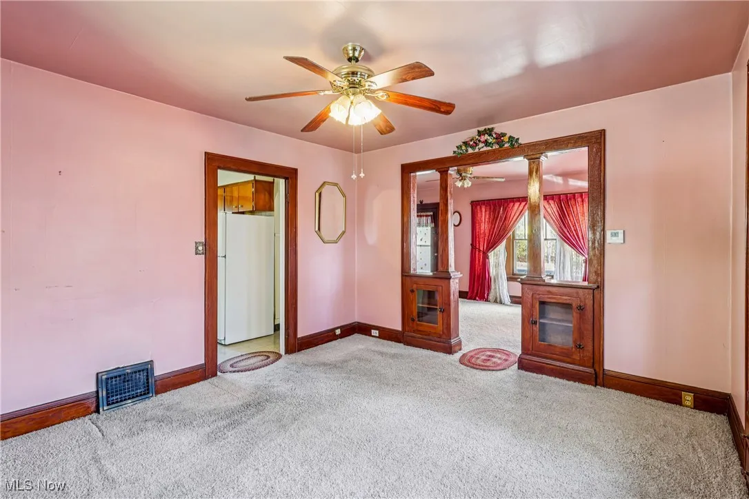 Dining room looking into kitchen and living room with carpet flooring