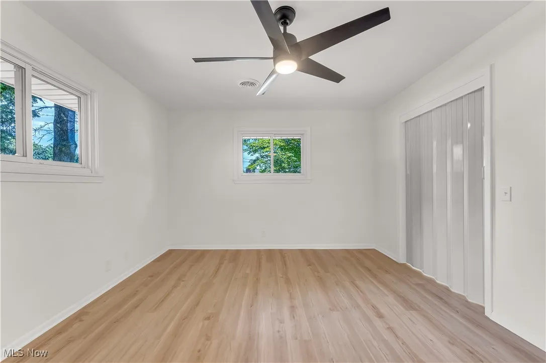 Spare room with light wood finished floors and ceiling fan